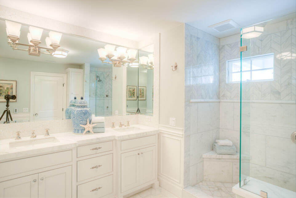 Make a small bathroom look bigger with light colors and glass enclosed shower