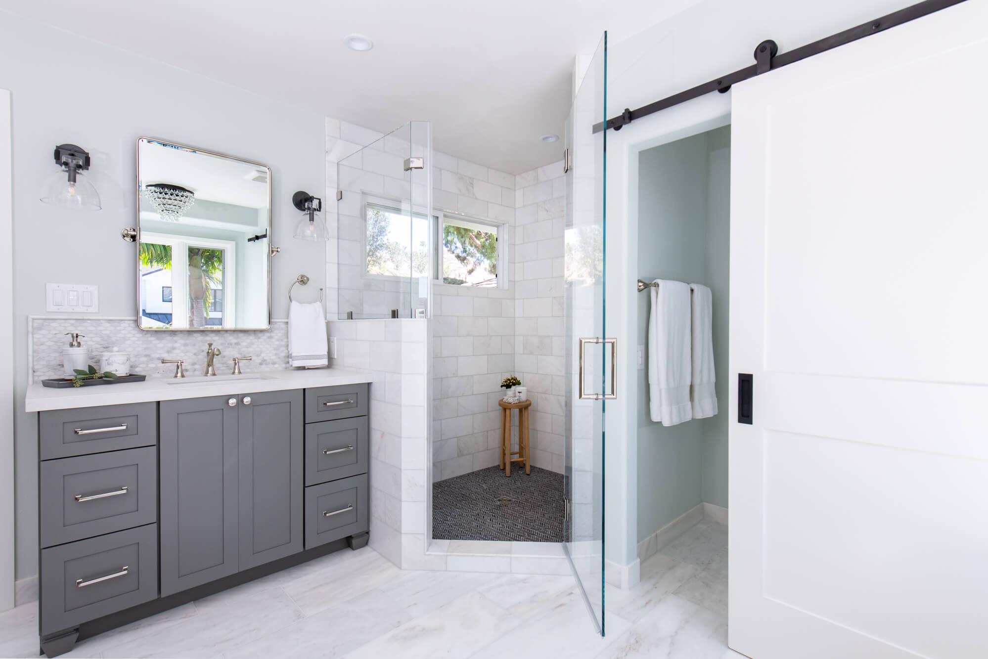 Marble Flooring and Shower Tile With Gray Cabinetry in Bathroom Remodel
