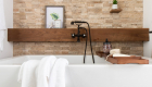 Rustic bathroom remodel with floating shelves and textured stone accent wall