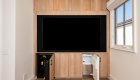 Custom cabinetry entertainment wall with hidden beverage fridge and ice maker