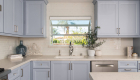 Blue kitchen cabinetry with white backsplash design