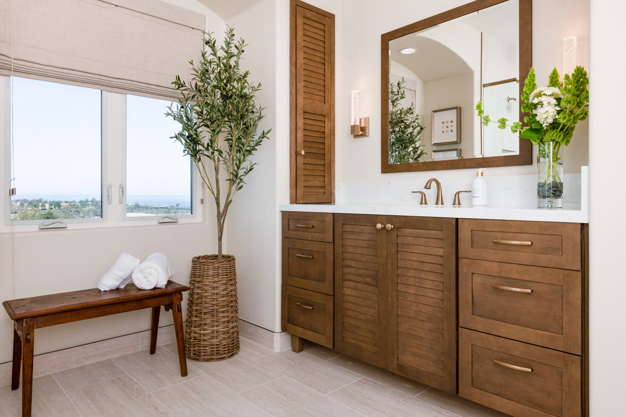 Newport Coast bathroom remodel with vanity, seating bench, and natural lighting