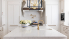7-two-pendant-light-fixtures-in-blue-and-gold-sit-above-large-kitchen-island