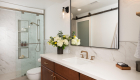 guest-bathroom-in-irvine-with-Emser-porcelain-tile-flooring-in-ivory-matte-and-Sea-Swell-Swing-Arm-Sconces-Black-Antique-brass