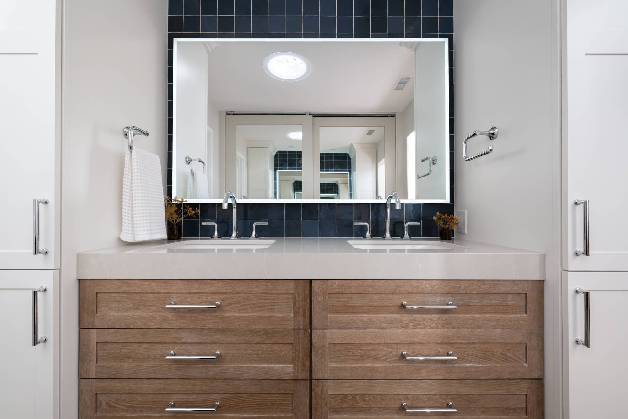 Fleurco-LED-vanity-mirror-Kohler-undermount-white-sink-and-polished-chrome-faucet-with-cane-design-and-lever-handles-and-towel-bar
