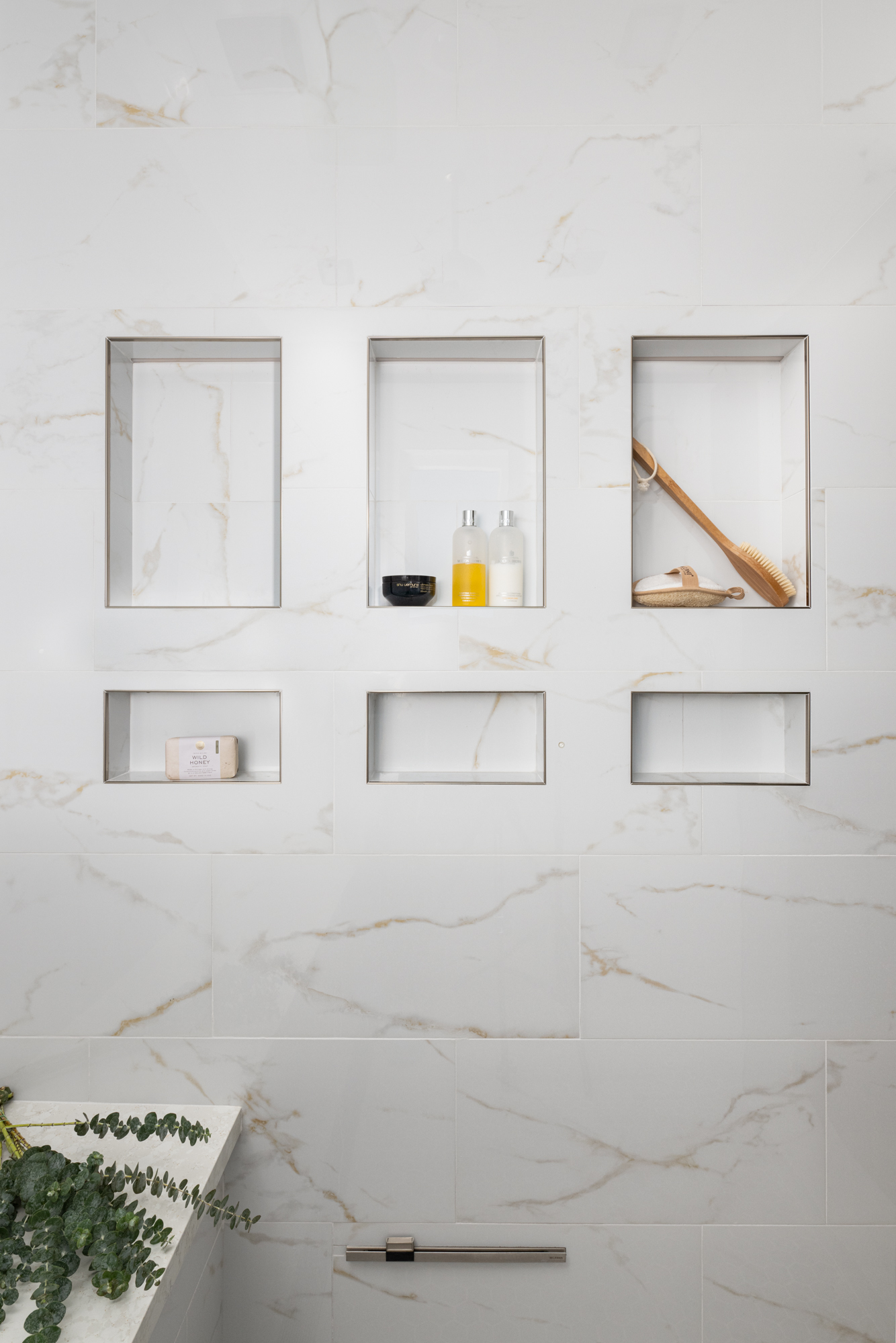 Shower-walls-bench-and-tub-surrounding-tiled-in-Polished-Oro-glazed-porcelain-in-the-Visconde-series-with-polished-nickel-trim