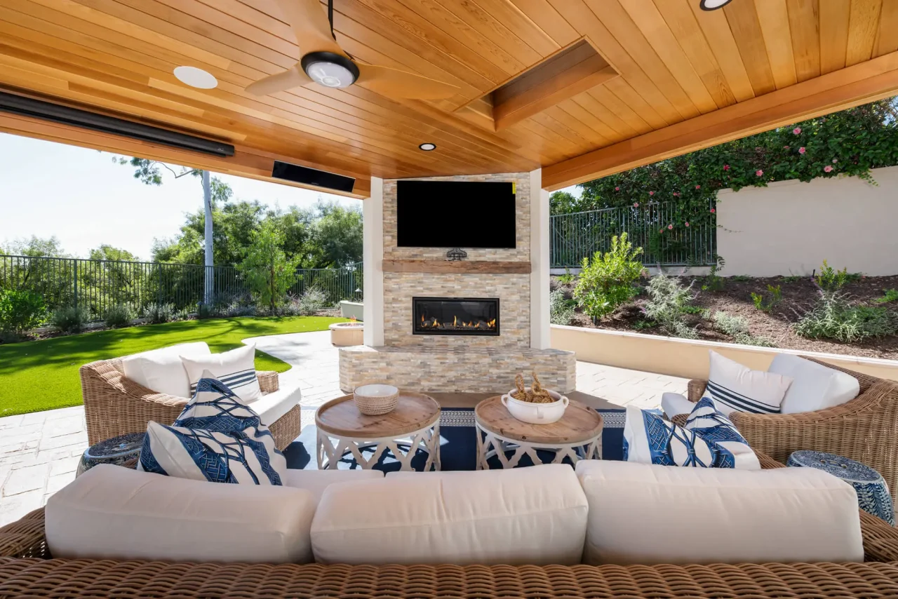 Outdoor entertainment space with ceiling fans and gas fireplace