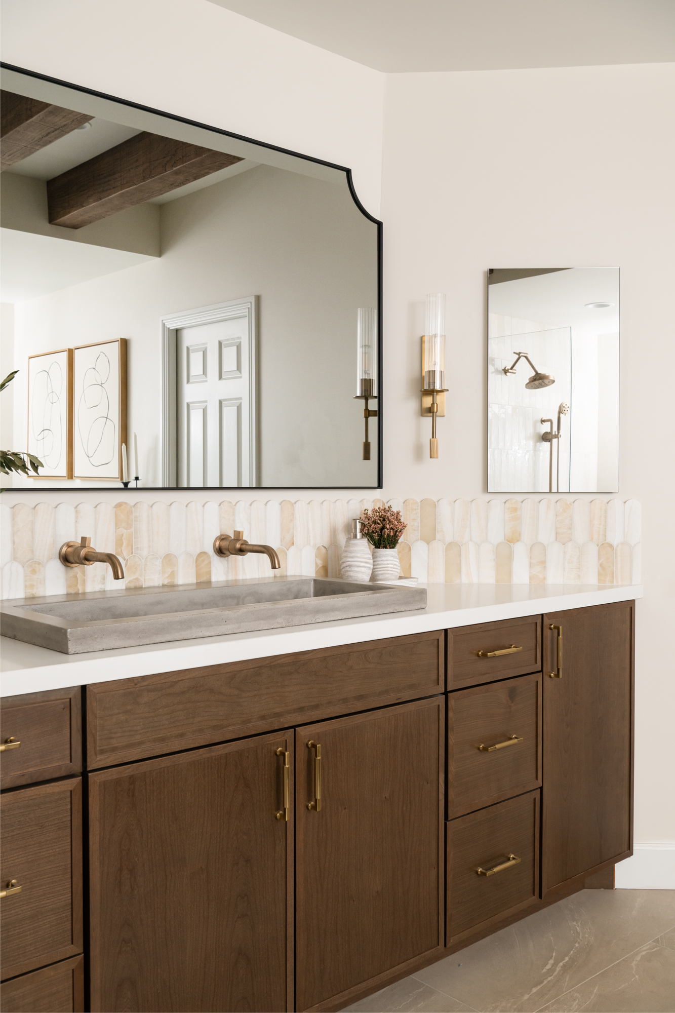 Patina-brass-wall-sconces-and-honey-bronze-pulls-at-vanity