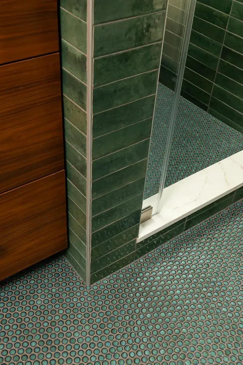 Sea-Pointe-Design-And-Remodel-shower-pan-and-main-flooring-in-turquoise-penny-rounds-with-quartz-curb-cap